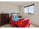 Cozy bedroom featuring a unique Jeep-themed bed, dresser, and a window with a neighborhood view at 608 E Pasaro Dr, Phoenix, AZ 85085