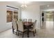 Elegant dining space with a dark wood table and upholstered chairs, illuminated by a modern chandelier at 608 E Pasaro Dr, Phoenix, AZ 85085