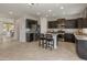 Spacious kitchen featuring dark cabinetry, granite countertops, and stainless-steel appliances, open to living areas at 608 E Pasaro Dr, Phoenix, AZ 85085