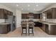 Beautiful kitchen with dark cabinets, granite countertops, island with seating, and stainless steel appliances at 608 E Pasaro Dr, Phoenix, AZ 85085