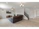 Open-concept living room with neutral tones and a comfortable sectional, adjacent to the staircase at 608 E Pasaro Dr, Phoenix, AZ 85085