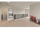 Second-floor loft area with neutral carpet, railing, and bright lighting, offering versatile space at 608 E Pasaro Dr, Phoenix, AZ 85085
