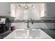 Close-up of a clean, white kitchen sink with modern faucet, complemented by a stylish backsplash at 6118 N 12Th Pl # 2, Phoenix, AZ 85014