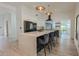 Bright kitchen featuring a waterfall island with bar seating, modern lighting, and stainless steel appliances at 6278 N 31St Way, Phoenix, AZ 85016
