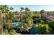 Aerial view of the property showing the pool and serene water features surrounded by lush landscaping and swaying palm trees at 10015 E Mountain View Rd # 2012, Scottsdale, AZ 85258