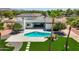 Beautiful backyard with pool, sleek patio, lush green grass, and desert landscaping at 10620 N 84Th St, Scottsdale, AZ 85260