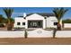 Stunning white home boasts modern design, desert landscaping, and a welcoming entryway with a tile roof at 10620 N 84Th St, Scottsdale, AZ 85260