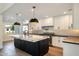 Modern kitchen boasts a large island, white cabinets, stainless steel appliances, and stylish lighting at 10620 N 84Th St, Scottsdale, AZ 85260