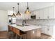 Modern kitchen with quartz countertops, stainless appliances, pendant lighting, and island seating at 10620 N 84Th St, Scottsdale, AZ 85260