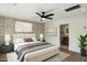 Inviting bedroom with a patterned accent wall, ceiling fan and neutral decor at 10620 N 84Th St, Scottsdale, AZ 85260