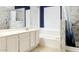 Bathroom featuring dual sinks, white cabinets, a bathtub, and a tiled shower with a blue and white shower curtain at 1132 E Harbor View Dr, Gilbert, AZ 85234
