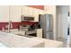 Well-lit kitchen featuring white cabinets, stainless steel appliances, and a sink with tiled countertops at 1132 E Harbor View Dr, Gilbert, AZ 85234