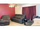 Cozy living room with a leather sofa, an armchair, neutral walls, and a ceiling fan at 1132 E Harbor View Dr, Gilbert, AZ 85234