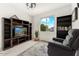 Cozy den with custom bookshelves, a comfortable armchair, and a large window offering natural light at 13554 W Briles Rd, Peoria, AZ 85383