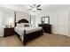 Spacious bedroom showcasing a wooden bed frame, matching dresser, hardwood floors, and a ceiling fan at 13554 W Briles Rd, Peoria, AZ 85383