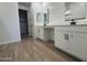 Bright bathroom featuring double vanities, tile floors, and a doorway leading to a walk-in closet at 15786 W Cheryl Dr, Waddell, AZ 85355
