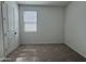 A bright bedroom with neutral carpet, white walls, and a window with blinds at 15786 W Cheryl Dr, Waddell, AZ 85355