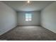 This is an unfurnished bedroom with neutral carpeting and a single window letting in natural light at 15786 W Cheryl Dr, Waddell, AZ 85355