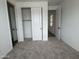 A cozy bedroom with neutral carpet and sliding closet doors at 15786 W Cheryl Dr, Waddell, AZ 85355