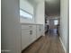 Bright kitchenette area with white cabinets, sleek countertops, and modern fixtures, adjacent to a window at 15786 W Cheryl Dr, Waddell, AZ 85355