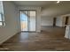 Bright living room with sliding glass doors leading to a patio, and wood-style tile flooring throughout at 15786 W Cheryl Dr, Waddell, AZ 85355