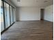 Spacious living room with sliding glass doors, wood-style tile flooring, and plenty of natural light at 15786 W Cheryl Dr, Waddell, AZ 85355