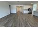 Open-concept living area with wood-look tile flooring that connects to a kitchen with white cabinets at 15786 W Cheryl Dr, Waddell, AZ 85355