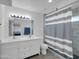 Bright bathroom featuring double sinks, a tile backsplash, and a shower with curtain at 10245 N 15Th Dr, Phoenix, AZ 85021
