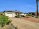Charming single-story home featuring an attached garage, desert landscaping and a large driveway at 10245 N 15Th Dr, Phoenix, AZ 85021