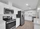 Modern kitchen featuring stainless steel appliances, white cabinetry and tile backsplash at 10245 N 15Th Dr, Phoenix, AZ 85021