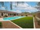 Expansive backyard featuring a sparkling pool, lush grass, and desert landscaping with mountain views at 10423 E Verbena Ln, Scottsdale, AZ 85255