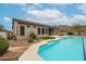Backyard oasis with a sparkling pool, lush grass, and desert landscaping with views of nearby mountains at 10423 E Verbena Ln, Scottsdale, AZ 85255
