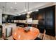 A warm dining area features a wooden table with chairs, dark cabinets, and stylish pendant lights at 10423 E Verbena Ln, Scottsdale, AZ 85255