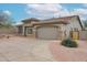 Stunning single-story home showcasing a tan exterior, spacious driveway, and attractive desert landscaping at 10423 E Verbena Ln, Scottsdale, AZ 85255