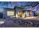 Inviting single-story home with a covered entrance, desert landscaping and illuminated entrance at 10423 E Verbena Ln, Scottsdale, AZ 85255