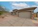 Single-story home showcasing a tan exterior, spacious driveway, desert landscaping and secure gate at 10423 E Verbena Ln, Scottsdale, AZ 85255