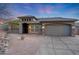 Beautiful single-story home featuring a spacious driveway, desert landscaping and lit exterior at 10423 E Verbena Ln, Scottsdale, AZ 85255