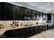 Modern kitchen showcasing dark cabinets, granite countertops, stainless steel appliances, and stylish lighting fixtures at 10423 E Verbena Ln, Scottsdale, AZ 85255