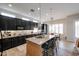 A stylish kitchen features dark cabinets, a granite island with sink, stainless steel appliances, and modern pendant lighting at 10423 E Verbena Ln, Scottsdale, AZ 85255
