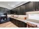 The modern kitchen features dark cabinetry, stainless steel appliances, granite countertops, and under cabinet lighting at 10423 E Verbena Ln, Scottsdale, AZ 85255