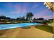 Backyard with pool, spa, and patio at twilight, complete with desert landscaping for a serene setting at 10423 E Verbena Ln, Scottsdale, AZ 85255