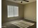 Sun-filled bedroom with a large window and neutral color scheme featuring blinds that create soft, diffused lighting at 11570 W Pima St, Avondale, AZ 85323