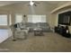 Spacious living room with a plush sectional sofa, ceiling fan, and large window for natural lighting at 11570 W Pima St, Avondale, AZ 85323