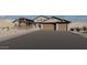 Charming home exterior with a large driveway, featuring a three-car garage and desert landscaping at 12053 W Palo Brea Ln, Peoria, AZ 85383