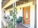 Inviting front porch featuring a beautiful wood door, seating area, and decorative plants at 1257 E Dartmouth St, Mesa, AZ 85203