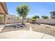 Beautiful backyard with desert landscape, mature tree, and block fence for privacy at 14521 W Gelding Dr, Surprise, AZ 85379