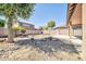 Spacious backyard with desert landscaping, a few shade trees, and block fence surround at 14521 W Gelding Dr, Surprise, AZ 85379