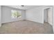 This spacious room features plush carpeting, natural light, and a neutral color palette at 14521 W Gelding Dr, Surprise, AZ 85379