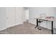 Bedroom with plush carpeting, neutral walls, desk, vanity, and a large sliding closet at 14521 W Gelding Dr, Surprise, AZ 85379