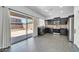 Open kitchen featuring dark cabinetry, modern appliances, and a seamless transition to outdoor space at 14521 W Gelding Dr, Surprise, AZ 85379